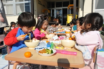 天気が良かったので外で食べる子どもたち